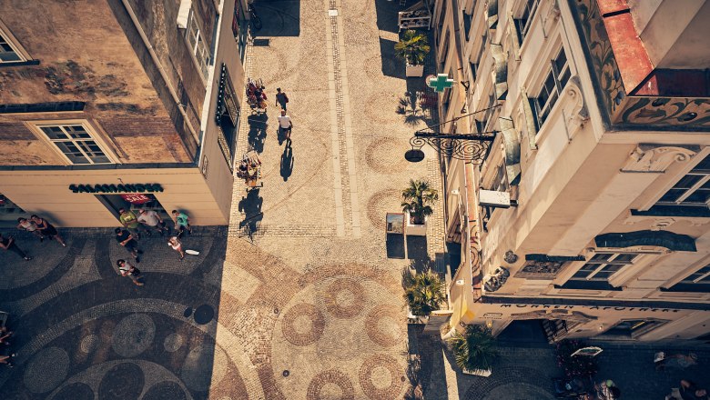 Old town of Krems, © Andreas Hofer Aerial view of a cobbled street in the old town of Krems with people and stores.