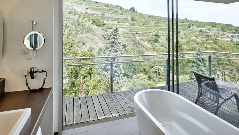 Steigenberger Krems vineyard suite, bathroom, © Steigenberger Hotel and Spa, Gregor Titze Bathroom with free-standing bathtub and view of vineyards.