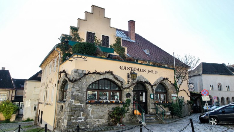 Hausansicht, © Amon-Jell Altes Haus von Außen mit Zaun und Parkplätzen