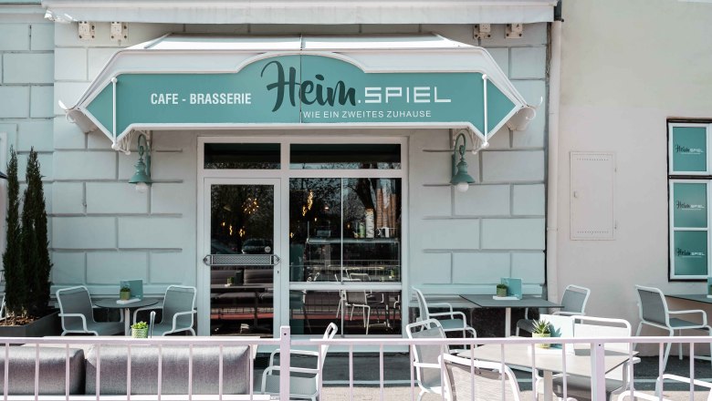 Exterior view, © Heim.Spiel/Kathi Kurzbauer Exterior view of a café with terrace and seating.