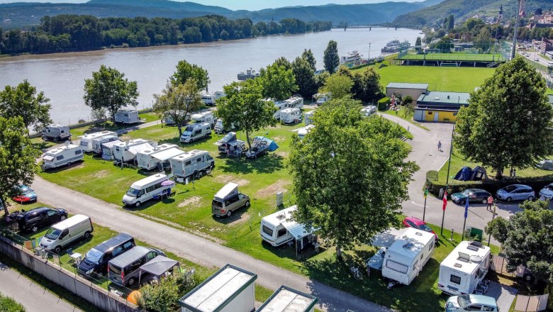 Camping Luftaufnahme, © ÖAMTC Zweigverein Krems Luftaufnahme eines Campingplatzes am Fluss mit Wohnmobilen und Zelten.