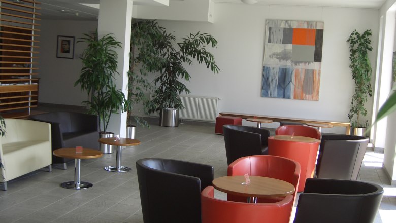 Kolping Campus Krems, LLC, © Kolping Campus Krems GmbH Modern lounge with colorful armchairs and plants.