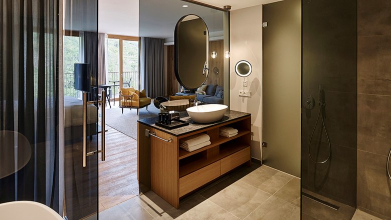 Steigenberger Krems, Goldbergsuite Bad, © Steigenberger Hotel and Spa, Gregor Titze Modern hotel room with open bathroom and shower.