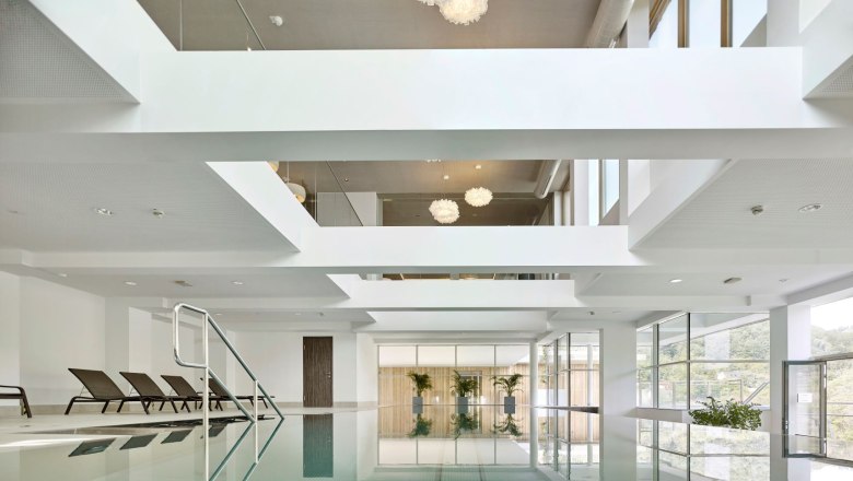 Steigenberger Krems, indoor pool, © Steigenberger Hotel and Spa, Gregor Titze Indoor pool with sun loungers and large windows.