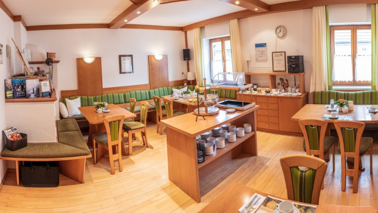 Frühstücksraum, © Michael Parak Ein gemütlicher Frühstücksraum mit Holzmöbeln, gedeckten Tischen und einem Buffet.