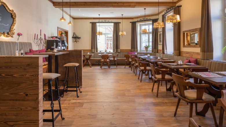 Restaurant Breakfast area, © Hotel Unter den Linden Cozy breakfast area with wooden furniture and large windows.