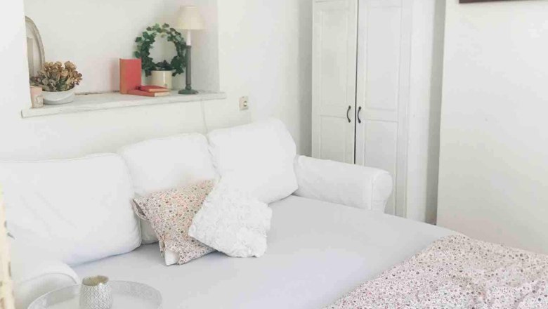 Cozy sleeping area with white sofa, side table and decorative elements.