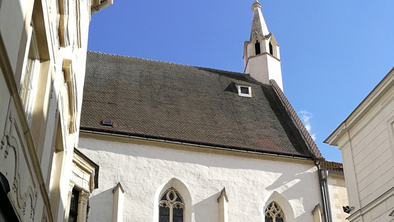 B&uuml;rgerspitalskirche in Krems with a pointed tower and Gothic windows.