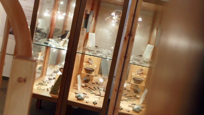 Vitrine im Urzeitmuseum mit pr&auml;historischen Artefakten.