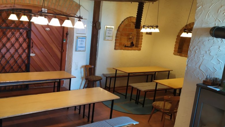 Interior view of a wine tavern with wooden tables, benches and rustic decoration.