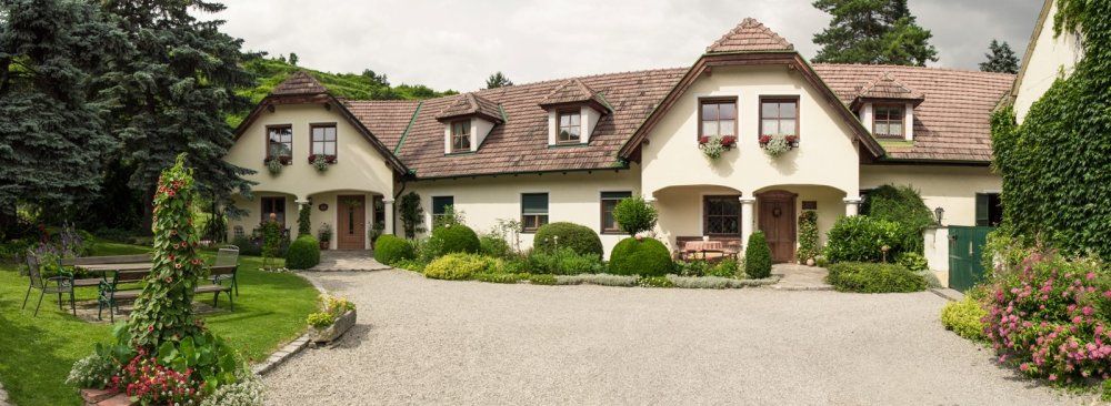 Ein traditionelles Landhaus mit gepflegtem Garten und Kiesweg.