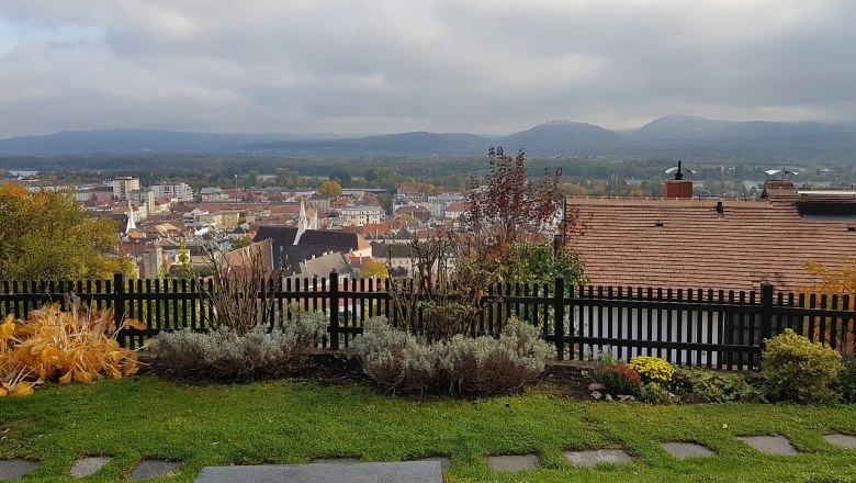 View over Krems, © Familie Gföhler View over the town of Krems with houses, hills and a cloudy sky in the background.