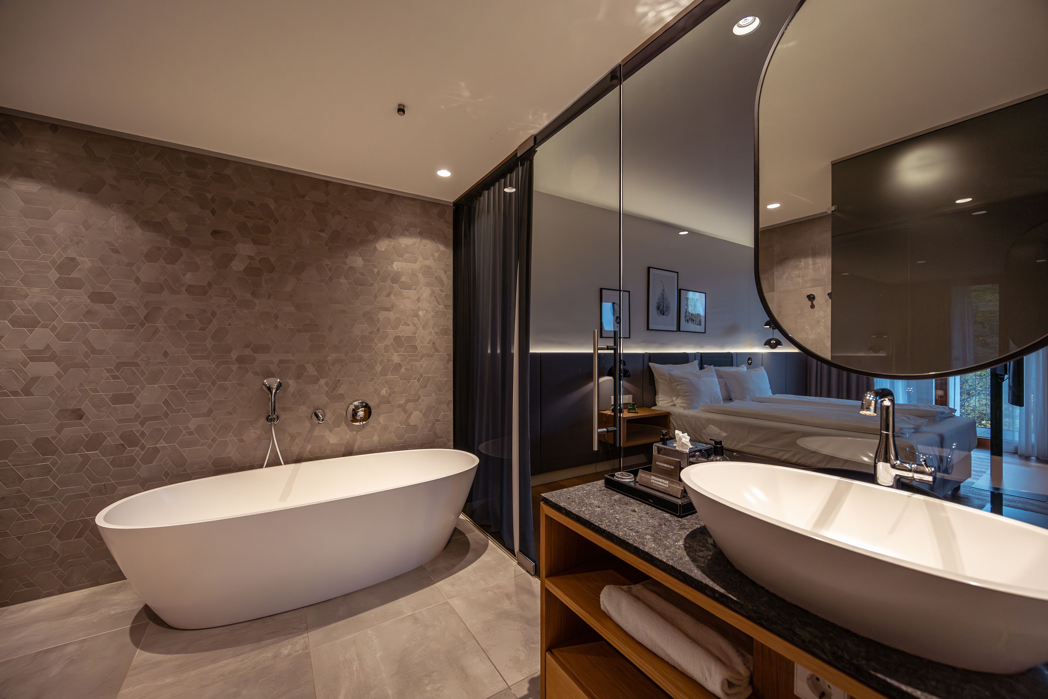 Modernes Hotelzimmer mit freistehender Badewanne und Waschbecken.
