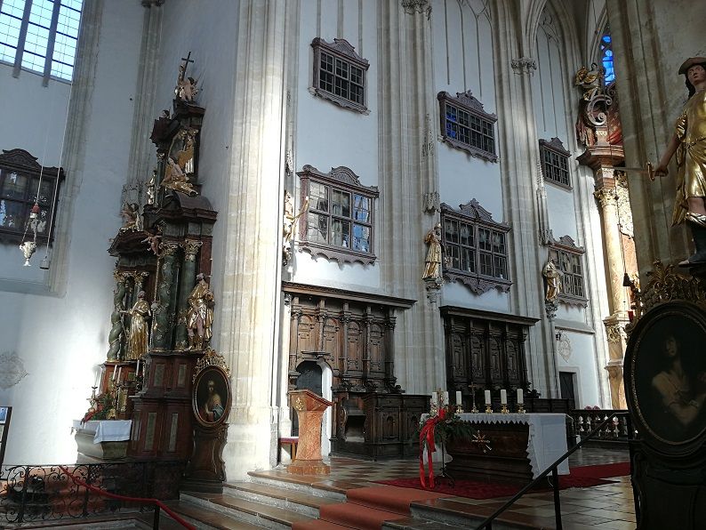 Innenansicht der Piaristenkirche mit Altar, Kanzel und Statuen.