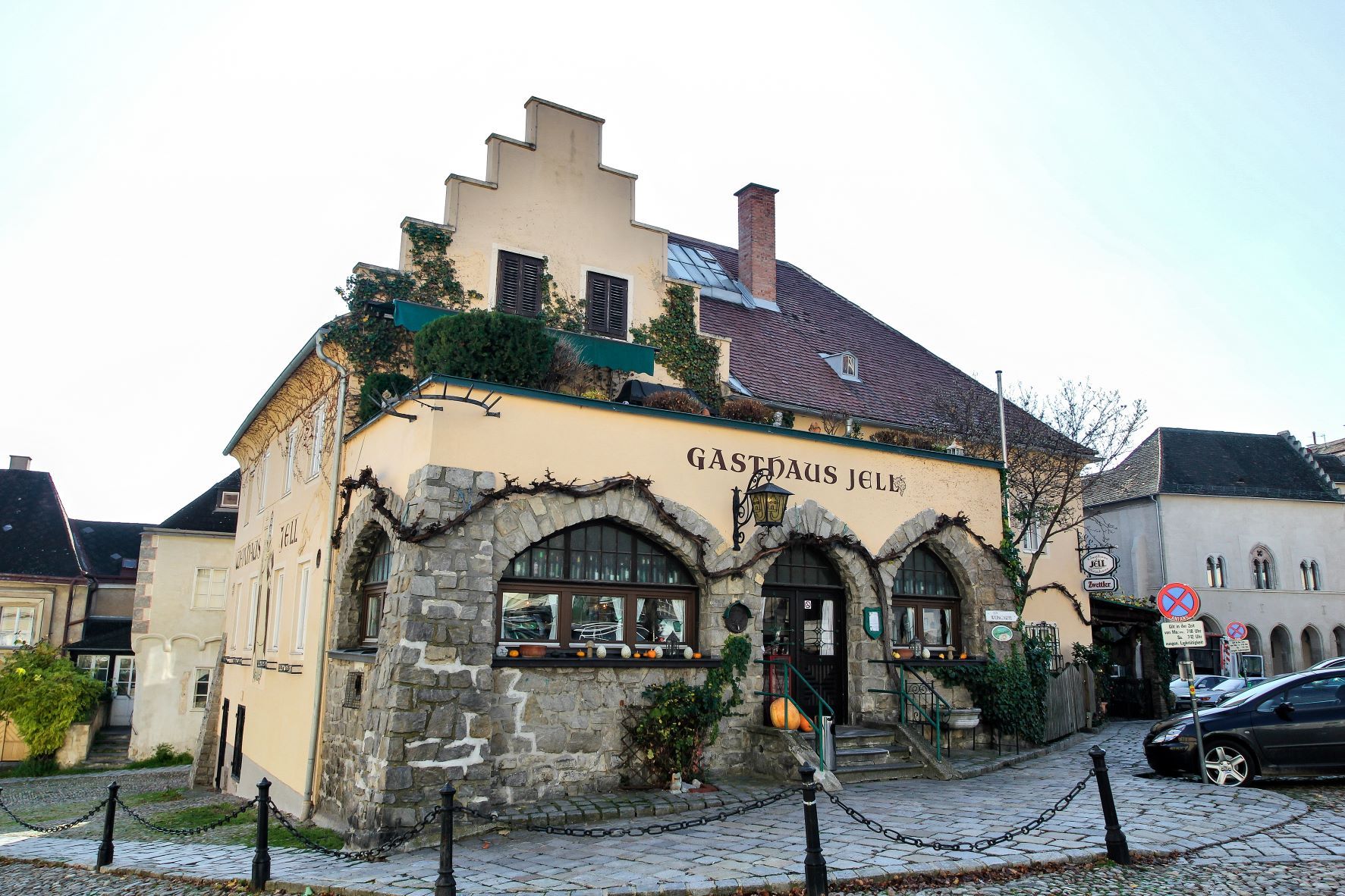 Altes Haus von Außen mit Zaun und Parkplätzen