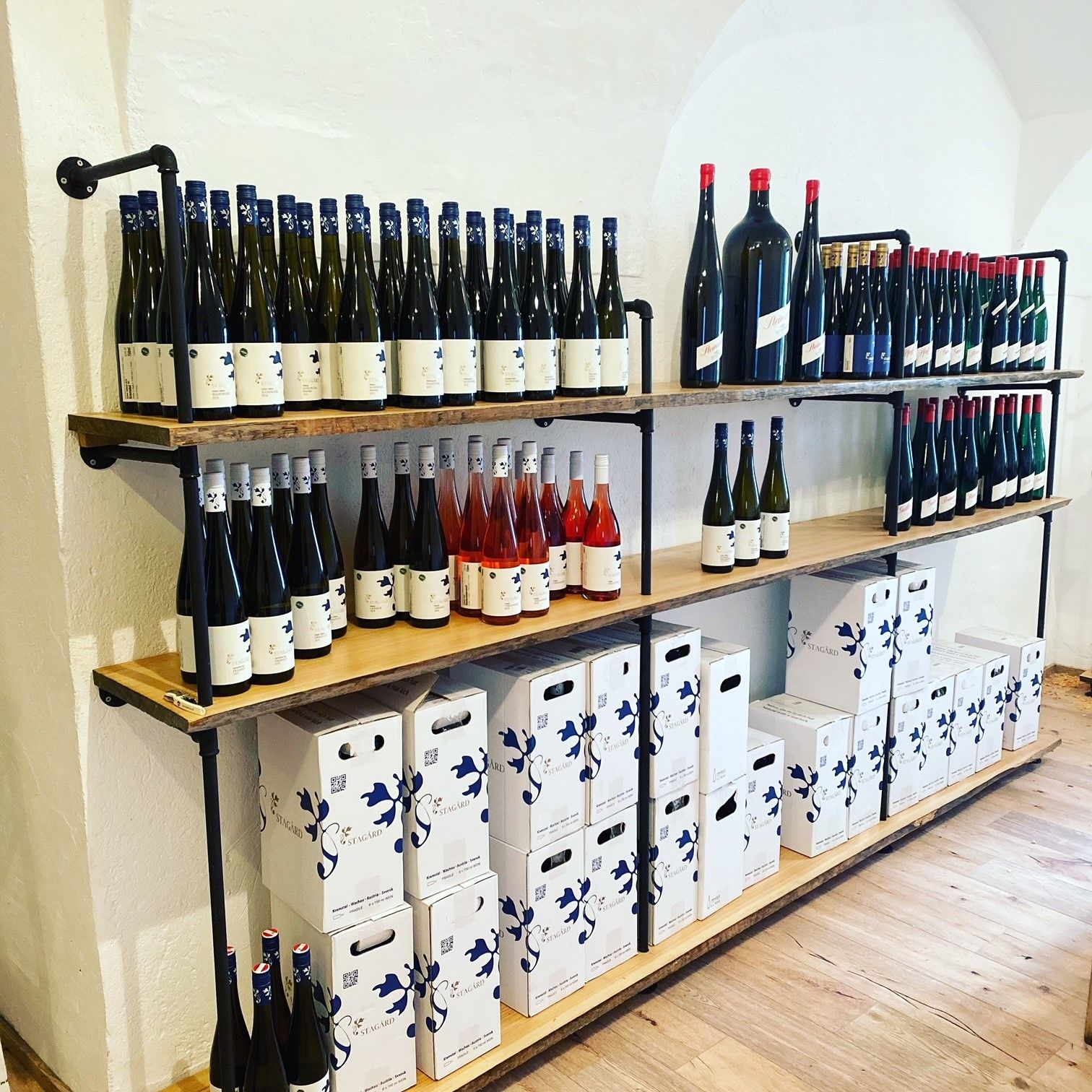 Regale mit Weinflaschen und Kartons in einer Vinothek.