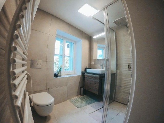 Modernes Badezimmer mit Dusche, Waschbecken und Toilette.