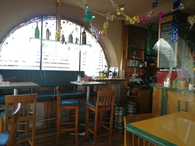 Innenansicht eines gemütlichen Cafés mit Dekorationen und Sitzgelegenheiten.