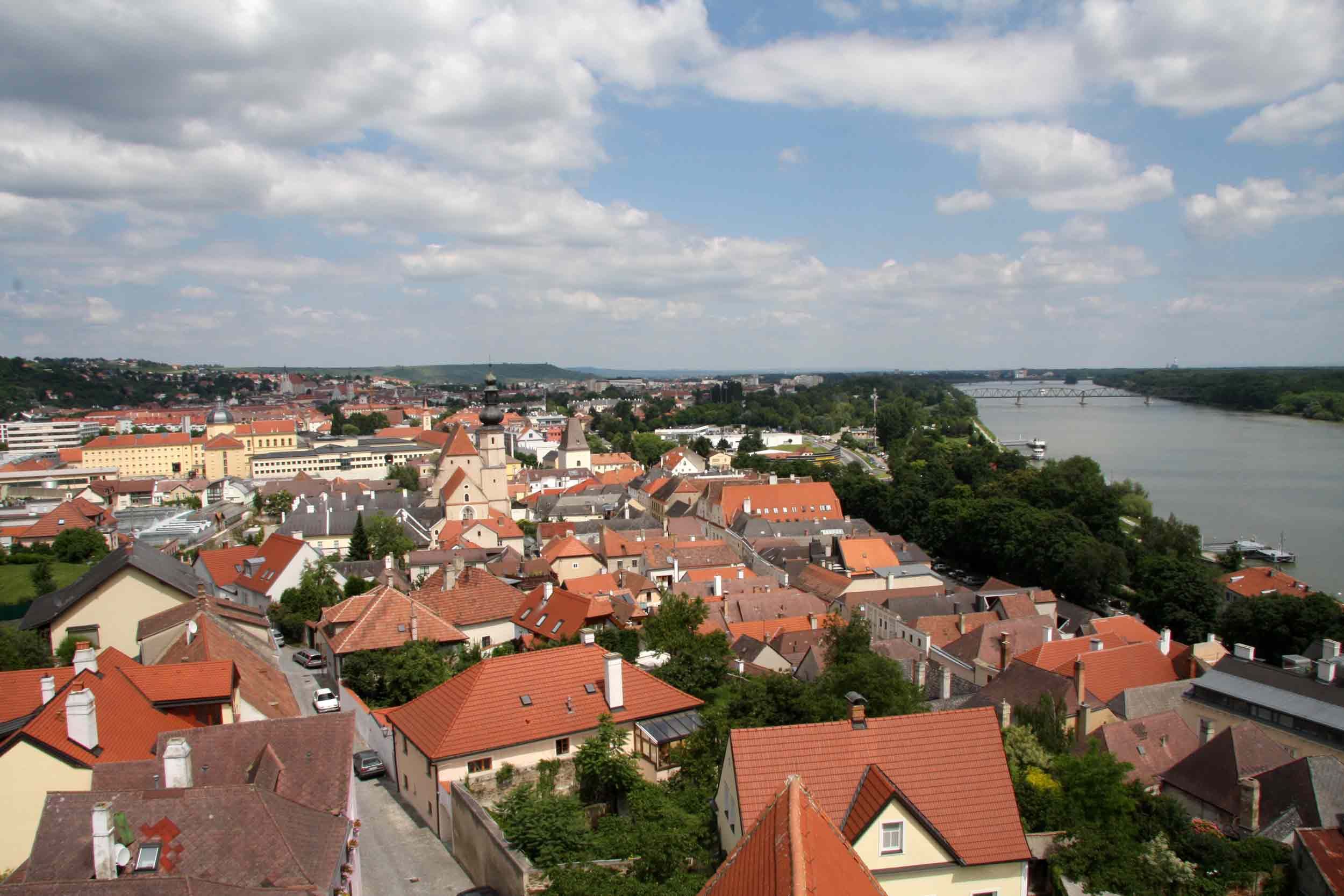 Panoramablick auf die Dächer von Krems mit Fluss und Brücke im Hintergrund.