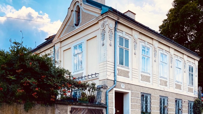 Au&szlig;enansicht einer historischen Villa mit verzierten Fenstern und einem Giebel.