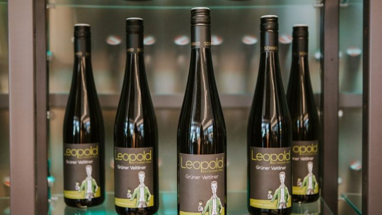 Five bottles of Gr&uuml;ne Veltliner wine from the Leopold brand on a shelf.
