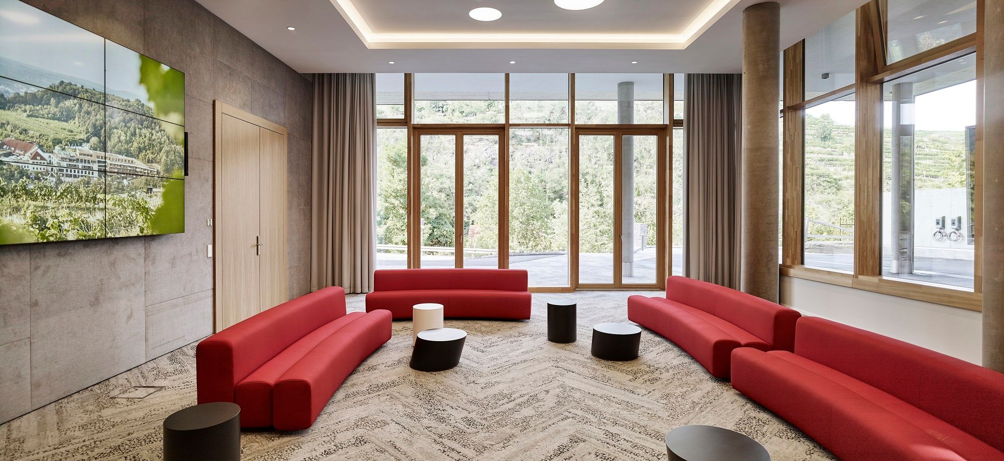 Moderner Tagungsraum mit roten Sofas und großen Fenstern im Steigenberger Krems.