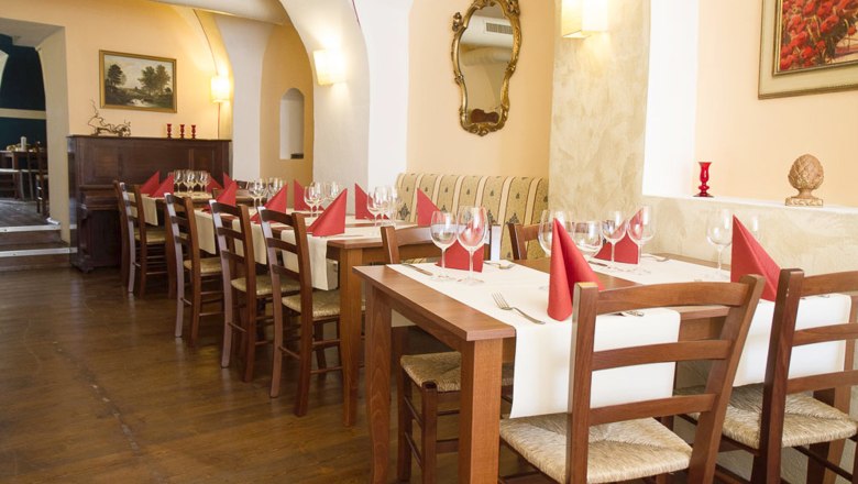 Elegantes Restaurant mit gedeckten Tischen und roten Servietten.