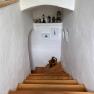 Wooden staircase in a white stairwell with decorations and pictures on the walls.