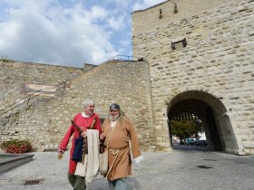 Two men in medieval clothing in front of an old stone wall in Hainburg an der Donau.