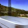 Panoramic view from a bathroom with bathtub and view of vineyards.