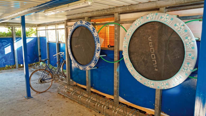 Bicycle garage with trampolines on the wall.