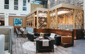 Innenansicht eines stilvollen Cafés mit modernen Möbeln und dekorativen Wänden.