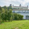 Wolfsberg Castle in the background with an orchard in the foreground.