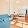 Bright hotel room with blue furniture and double bed.