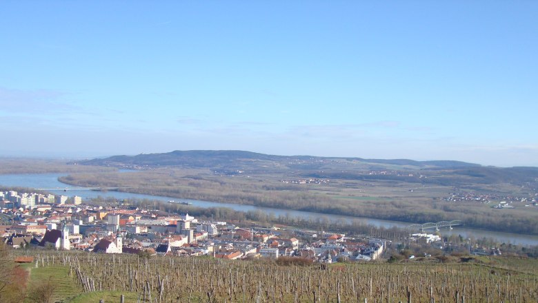 Panoramablick auf Krems an der Donau mit Fluss und Weinbergen.