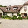 A traditional country house with a well-kept garden and gravel path.