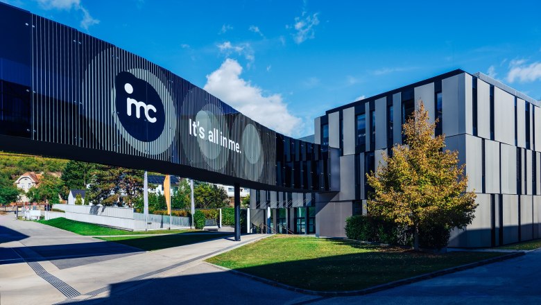 Modernes Geb&auml;ude der IMC Krems mit Glasbr&uuml;cke und Schriftzug 'It's all in me'.