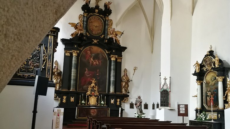 Interior view of the B&uuml;rgerspitalskirche in Krems with altar and religious paintings.