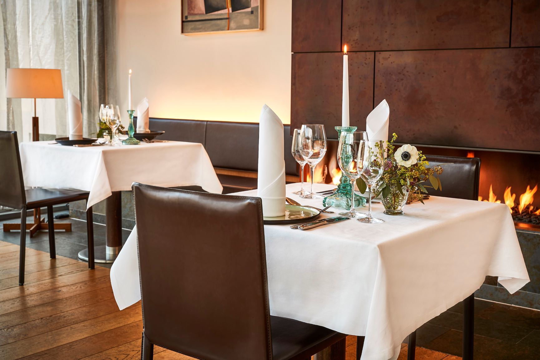 Elegantes Restaurant mit gedecktem Tisch, Kerzen und Kamin.