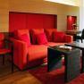 Modern suite with red furniture and wooden walls.