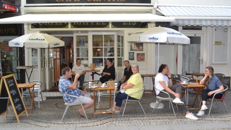 Menschen sitzen vor einem Café mit dem Namen Café Centro.