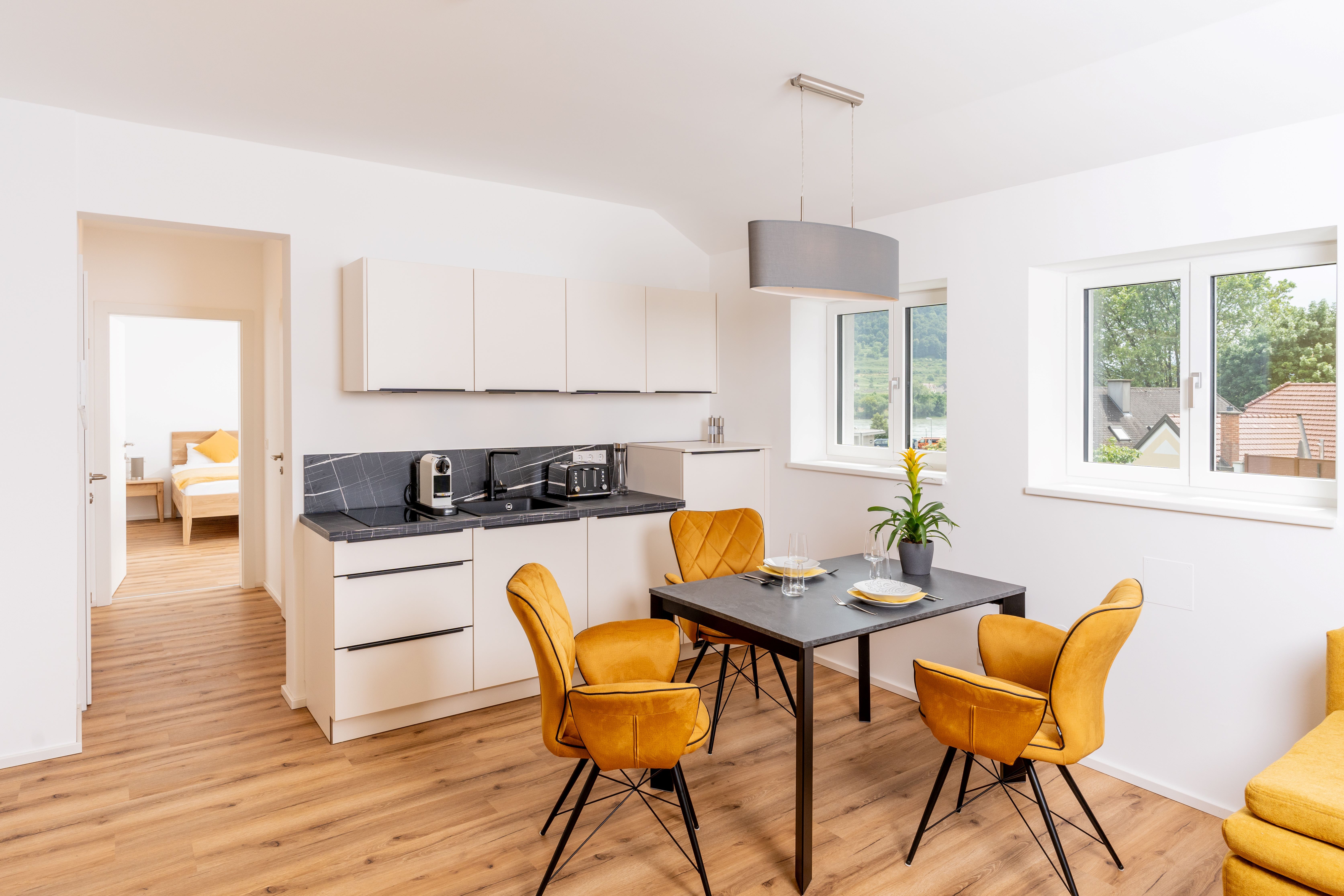 Moderne Küche mit Esstisch und gelben Stühlen in einer Ferienwohnung.