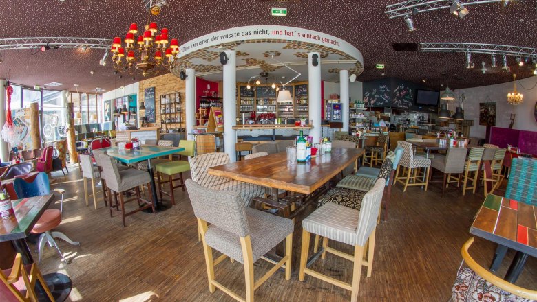 Innenraum eines stilvollen Caf&eacute;s mit Holzm&ouml;beln und dekorativen Elementen.