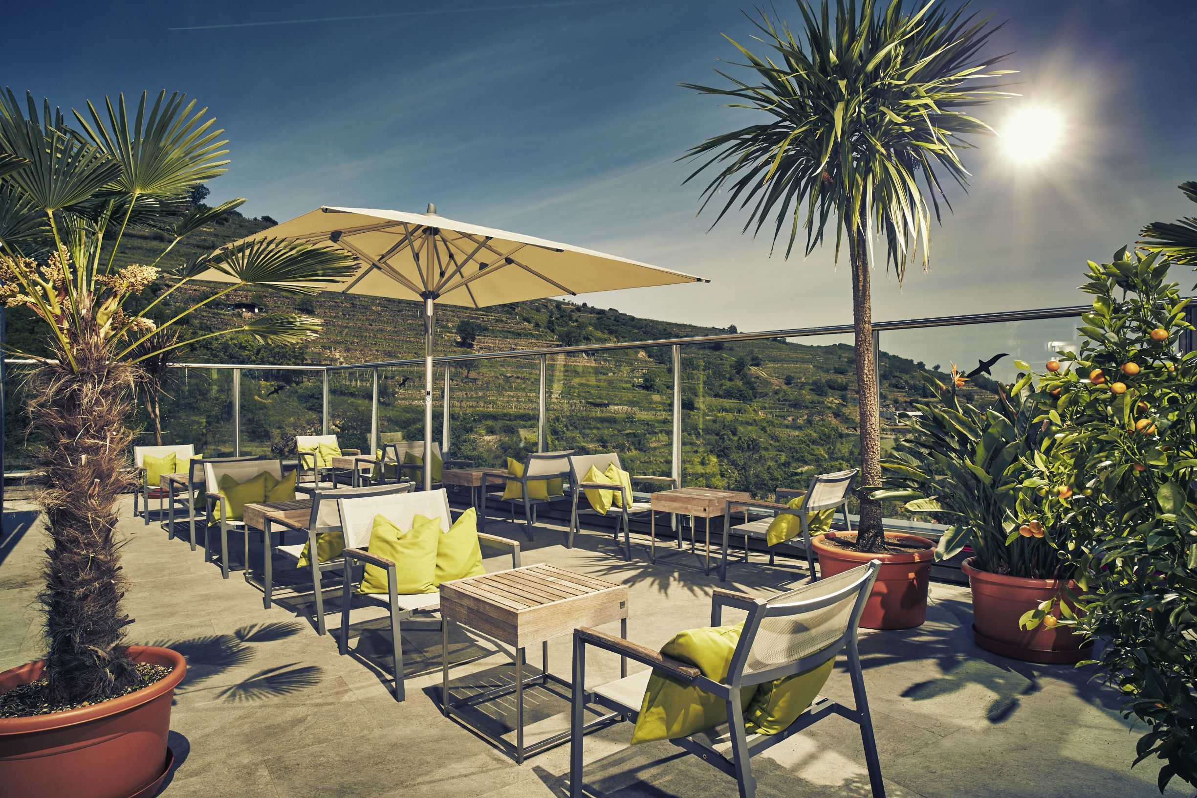 Terrasse des Steigenberger Krems mit Sonnenschirmen und Pflanzen.