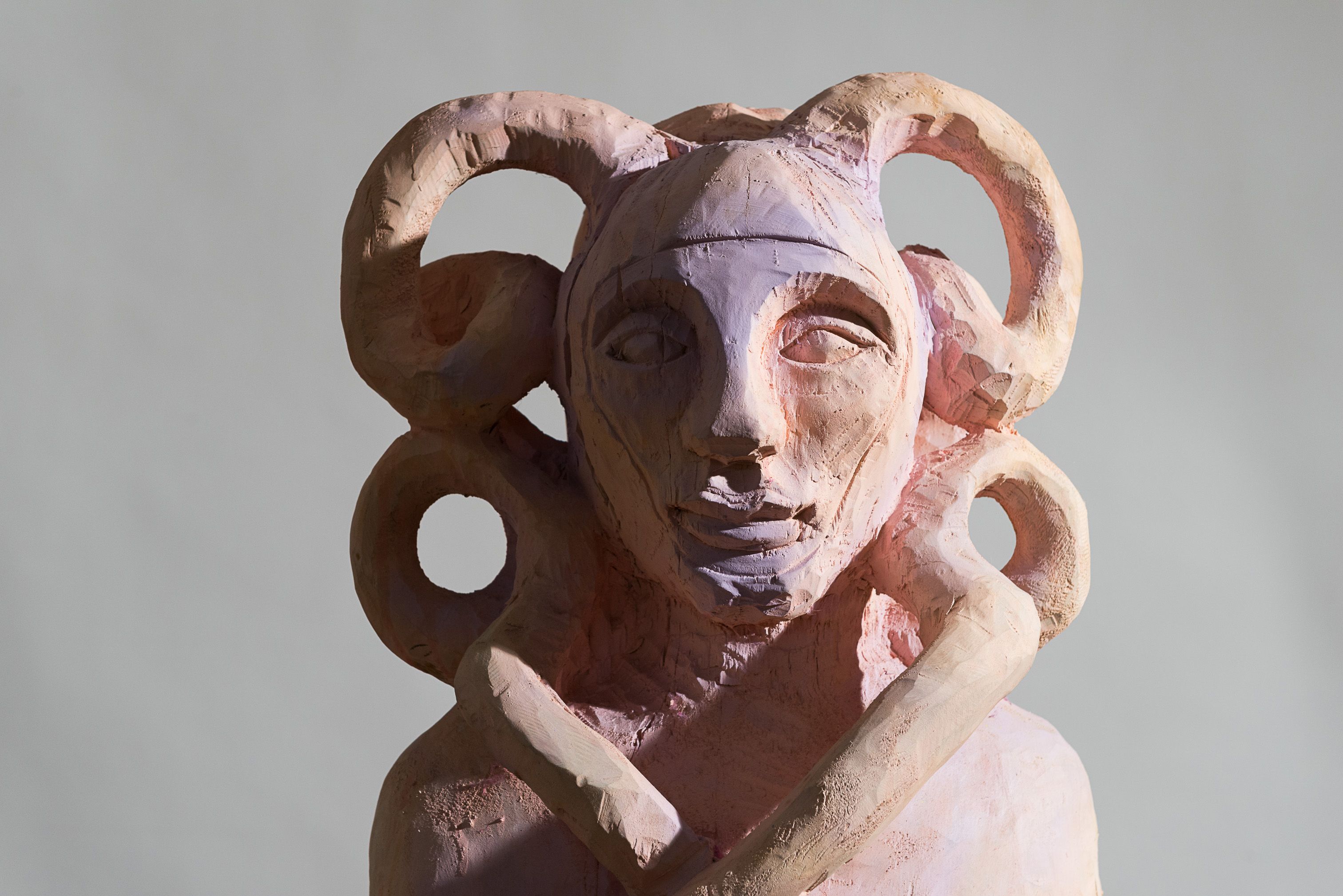 Skulptur mit Hörnern und abstraktem Gesicht.
