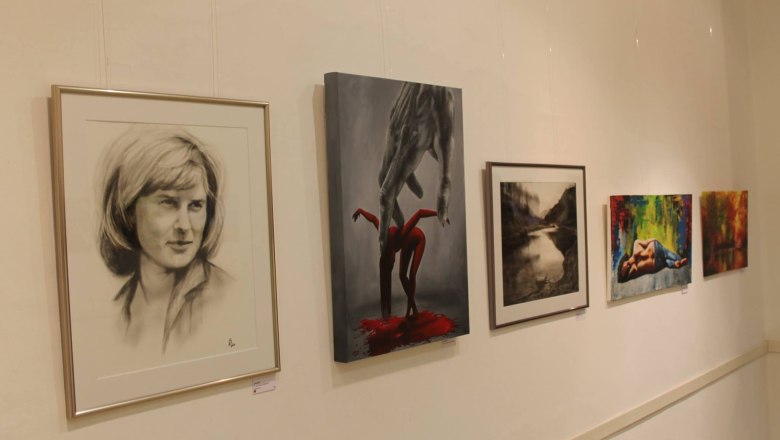 F&uuml;nf Kunstwerke h&auml;ngen an einer wei&szlig;en Wand in einer Galerie.