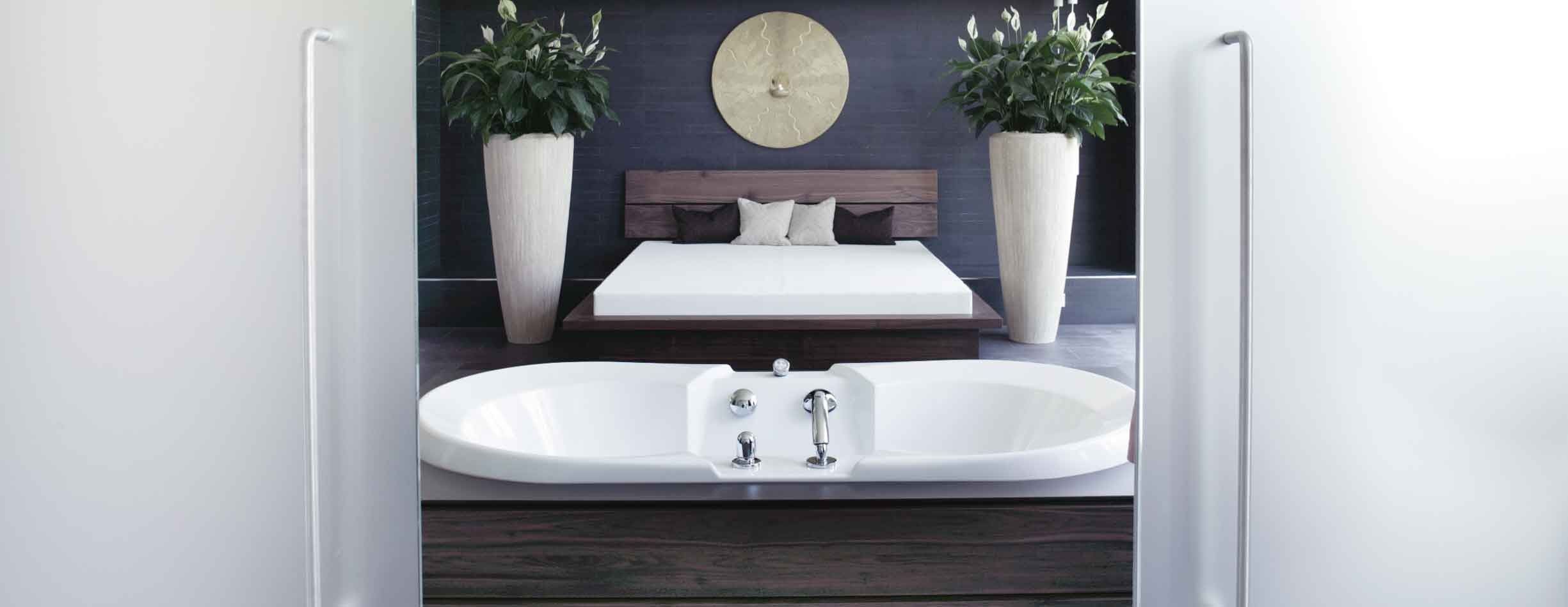 Moderner Spa-Bereich mit Badewanne, Bett und Pflanzen.