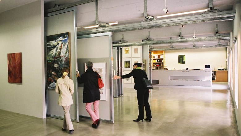 Interior view of an art library with people looking at works of art.