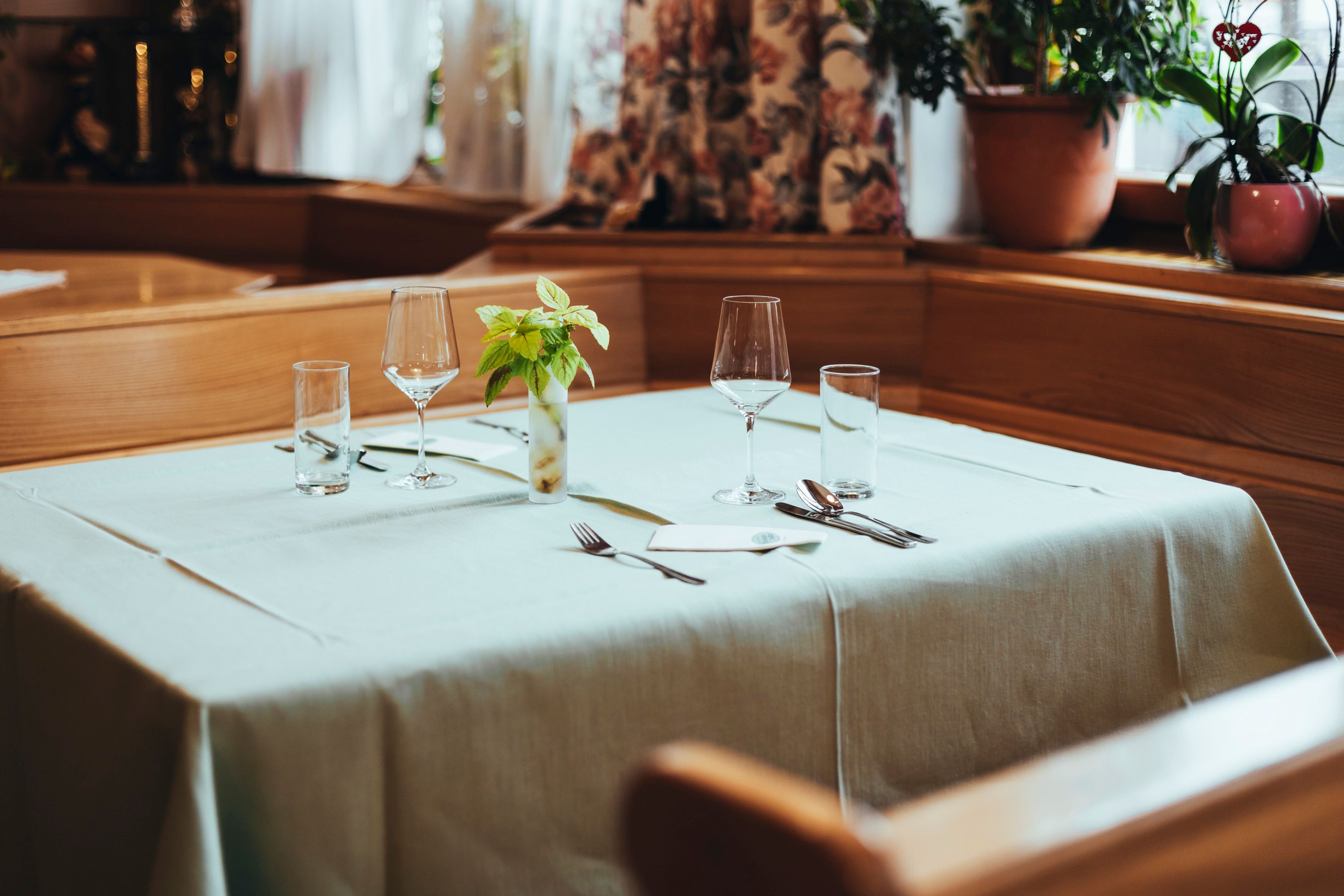 Eleganter Tisch in einem Restaurant mit Gläsern und Besteck gedeckt.