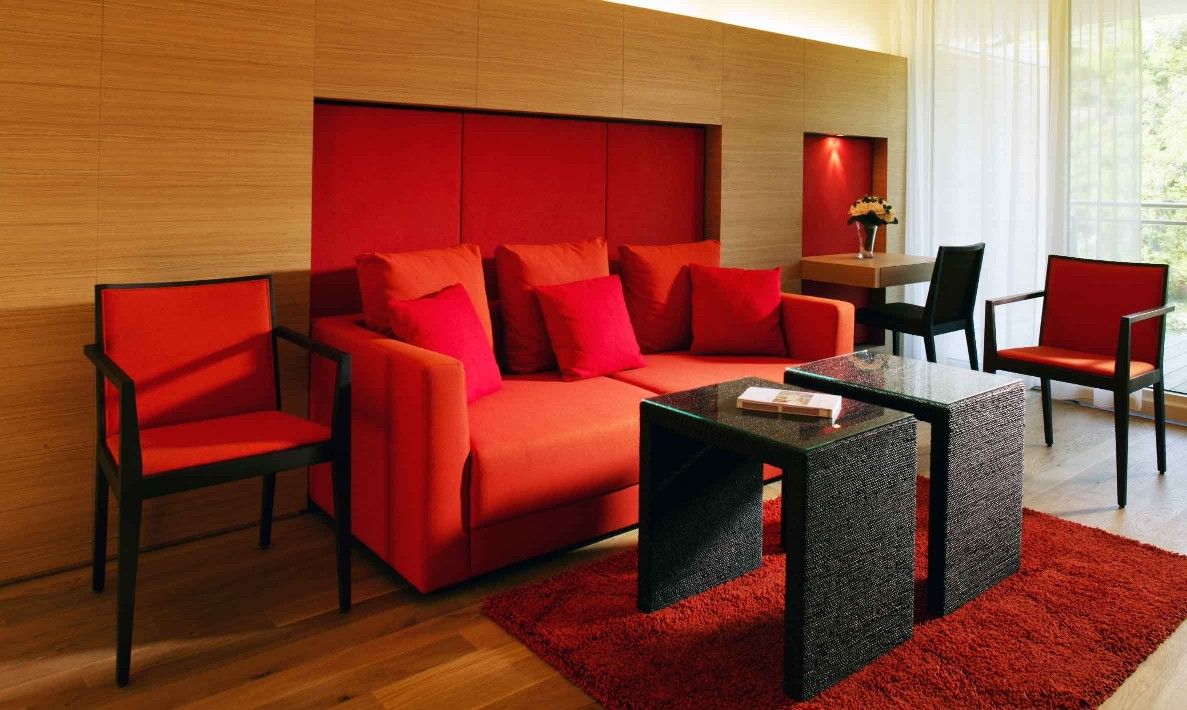 Moderne Suite mit roten Möbeln und Holzwänden.